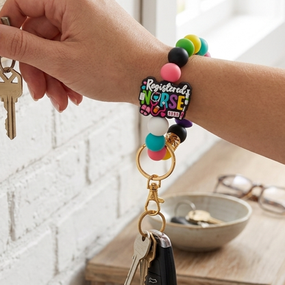 Colorful beaded keychain with 'Registered Nurse' tag attached to keys, held by a hand.